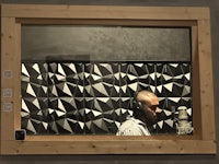 a man in a recording studio with a microphone in front of a window