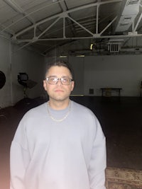 a man in glasses standing in a room