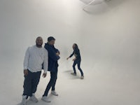 three people standing in a white room