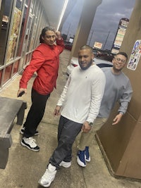 three people standing in front of a fast food restaurant