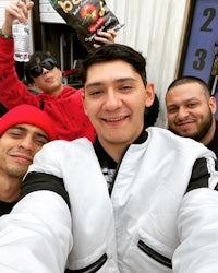 a group of men taking a selfie in front of a building