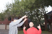 two men pointing at each other in a driveway